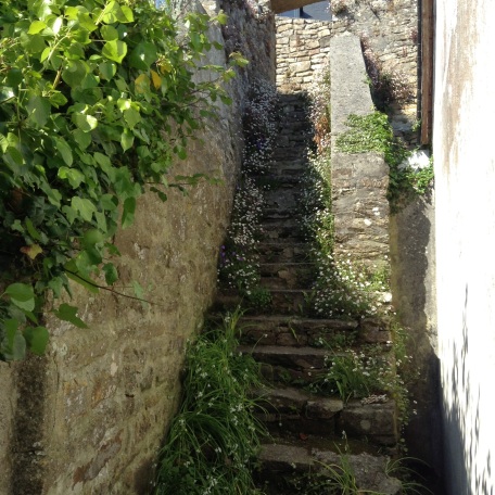 1) Stone steps at the side of the cottage rise steeply up to join the ancient walled pathways that lead up to the town